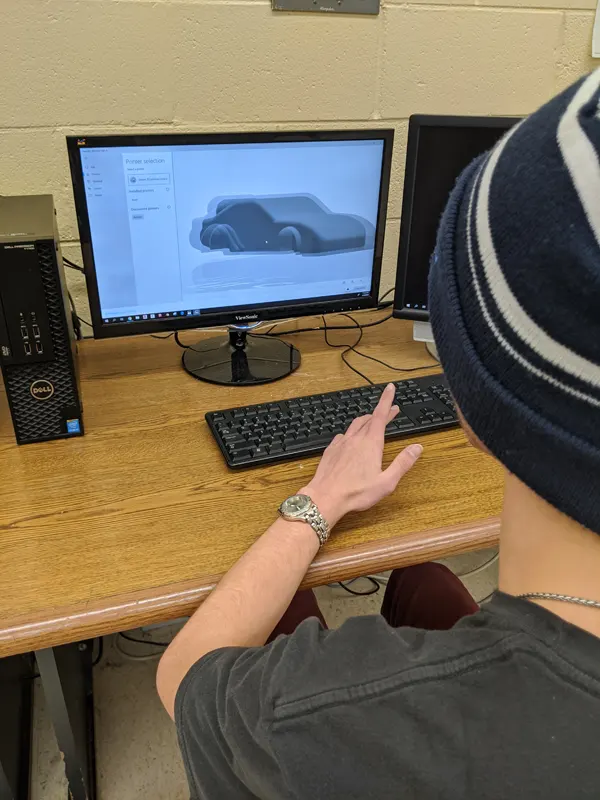 Student constructing a car drawing on the computer