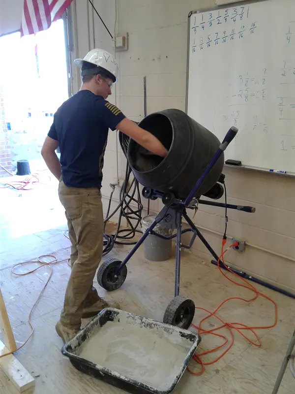 Student works with a cement mixer