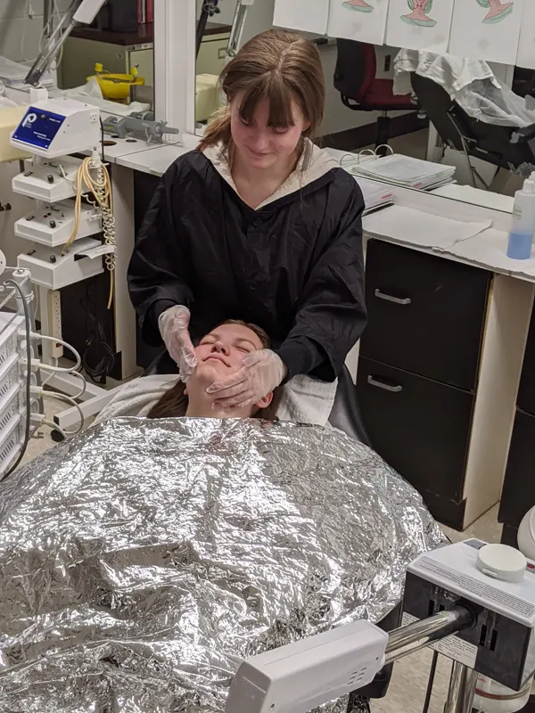 Student giving another student a facial