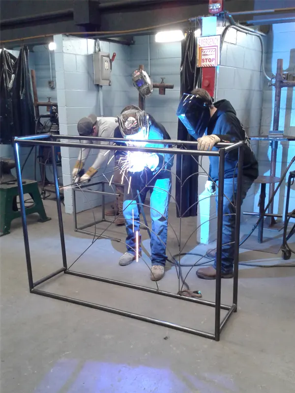 Students welding metal frame