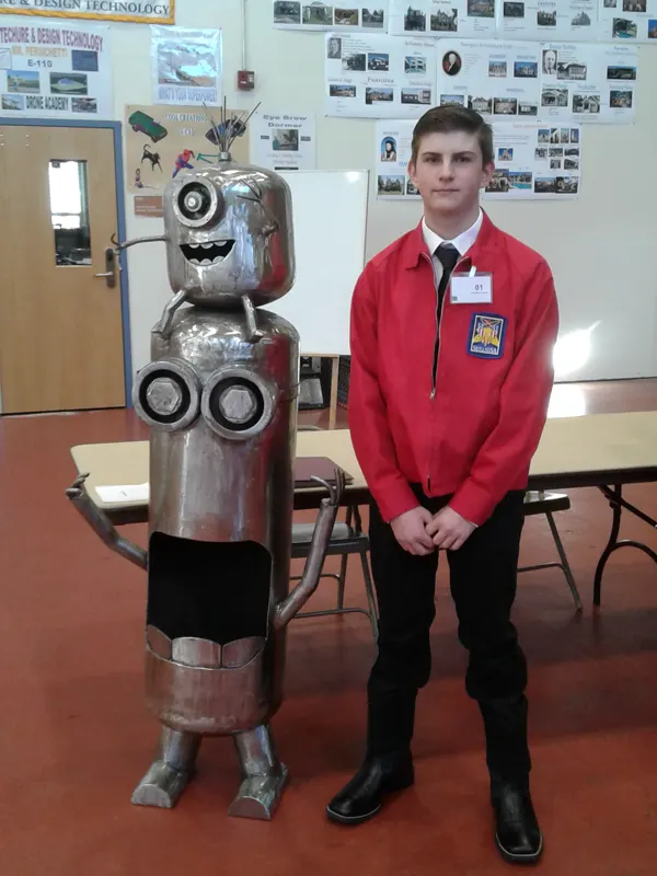 Student poses with his metal welded Minions statue