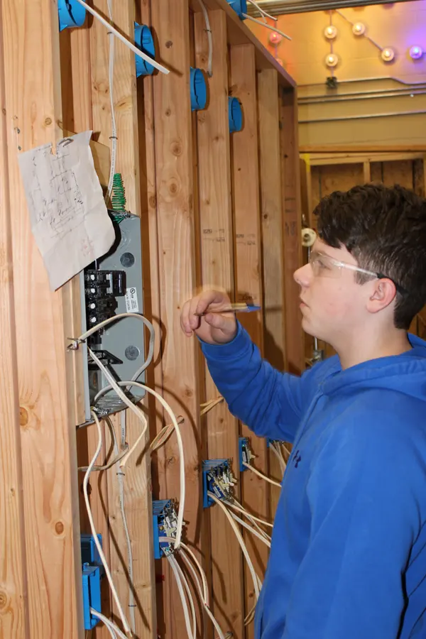 Student working with circuit breaker box